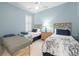 Cozy bedroom with two twin beds, unique headboards, a ceiling fan, and light blue walls at 5751 Wilena Pl, Sarasota, FL 34238