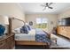 Bright bedroom with wood floors, ceiling fan, bench seat, and views of the pool at 5751 Wilena Pl, Sarasota, FL 34238