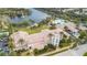 Aerial view of the community clubhouse featuring a clock tower, palm trees, and a lake with a fountain at 5751 Wilena Pl, Sarasota, FL 34238