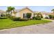 Beautiful home exterior featuring a manicured lawn, blooming shrubbery, and an inviting facade at 5751 Wilena Pl, Sarasota, FL 34238