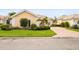 Well-maintained front yard with lush green grass, manicured shrubbery, and a quaint flower tree at 5751 Wilena Pl, Sarasota, FL 34238