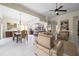 Open-concept living space with a ceiling fan, tile flooring and open flow to the kitchen and dining areas at 5751 Wilena Pl, Sarasota, FL 34238