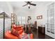 Well-lit home office featuring hardwood floors, orange chairs, a ceiling fan, and built-in shelves at 5751 Wilena Pl, Sarasota, FL 34238