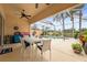Covered patio with dining table overlooking a screened pool area and beautiful landscaping at 5751 Wilena Pl, Sarasota, FL 34238