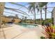 Screened-in pool area with comfortable lounge chairs, surrounded by mature landscaping and view of community bridge at 5751 Wilena Pl, Sarasota, FL 34238