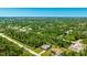 Expansive aerial view of a home with a pool, set amongst a lush, green landscape and neighborhood at 5826 David Blvd, Port Charlotte, FL 33981