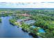 Aerial view of tennis courts, lake with fountain, and community buildings amidst lush landscaping at 5881 Girona Pl, Sarasota, FL 34238