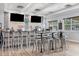 The modern bar features sleek bar stools, multiple TV screens, and a fully stocked liquor selection at 5881 Girona Pl, Sarasota, FL 34238