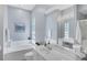 A bright bathroom with a large tub, a glass block window, and a vanity with a large mirror at 5881 Girona Pl, Sarasota, FL 34238