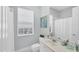 A bright bathroom with a window and a shower and tub combination at 5881 Girona Pl, Sarasota, FL 34238