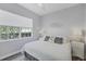A bright bedroom with a large window and white bedding at 5881 Girona Pl, Sarasota, FL 34238