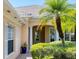 Charming home exterior with a well-manicured front yard, columns, and an arched entryway at 5881 Girona Pl, Sarasota, FL 34238