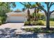 Inviting single-story home featuring a tile roof, brick driveway, and tropical landscaping at 5881 Girona Pl, Sarasota, FL 34238