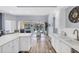 Well-lit kitchen featuring white cabinets, stainless steel appliances, and an open layout with a view at 5881 Girona Pl, Sarasota, FL 34238