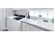 Bright laundry room with modern, front-loading washer and dryer and a convenient utility sink at 5881 Girona Pl, Sarasota, FL 34238