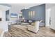 Open living room with hardwood floors, stylish decor, and a view of the kitchen at 5881 Girona Pl, Sarasota, FL 34238