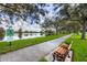 Scenic lakeside path with park bench, walking trail, and lush trees for a tranquil outdoor experience at 5881 Girona Pl, Sarasota, FL 34238