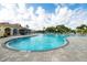The outdoor pool features crystal-clear water, ample lounge chairs, and lush tropical landscaping at 5881 Girona Pl, Sarasota, FL 34238