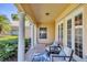 Covered porch with columns and outdoor seating offers a welcoming space to relax and enjoy the view at 5881 Girona Pl, Sarasota, FL 34238