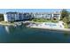 Scenic aerial view of the condo building near the water, featuring a pool and private boat dock at 600 Sutton Pl # B305, Longboat Key, FL 34228