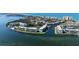 Aerial view of waterfront condos, lush landscaping, docks, and canal leading to the ocean at 600 Sutton Pl # B305, Longboat Key, FL 34228