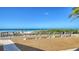 Beautiful beach view with blue skies and ocean, featuring a wooden walkway to benches by the ocean at 600 Sutton Pl # B305, Longboat Key, FL 34228