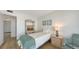 Bedroom with a single bed, rattan shelving and decor, and natural wood flooring at 600 Sutton Pl # B305, Longboat Key, FL 34228