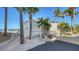 Charming beach structure with a ramp, surrounded by palm trees, rocks and a paved walkway to the beach at 600 Sutton Pl # B305, Longboat Key, FL 34228