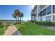 Well-manicured lawn and walkway next to condominium with waterfront views and boat docks at 600 Sutton Pl # B305, Longboat Key, FL 34228