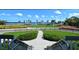 Inviting waterfront view with lush green lawn, palm trees, and a charming walking path at 600 Sutton Pl # B305, Longboat Key, FL 34228