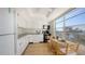 Bright kitchen featuring white cabinets, appliances, wood-look floors and a table, with a view of the river at 600 Sutton Pl # B305, Longboat Key, FL 34228