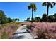 Walking path with lush greenery and palm trees in the park overlooking the bay at 600 Sutton Pl # B305, Longboat Key, FL 34228