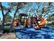 Playground with slides and climbing equipment under mature shade trees at 600 Sutton Pl # B305, Longboat Key, FL 34228