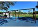Playground with swings and various play equipment surrounded by lush green grass at 600 Sutton Pl # B305, Longboat Key, FL 34228