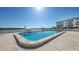 Community swimming pool overlooking the water, with lounge chairs and picturesque views at 600 Sutton Pl # B305, Longboat Key, FL 34228