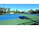 Well-maintained tennis court surrounded by lush greenery and palm trees at 600 Sutton Pl # B305, Longboat Key, FL 34228