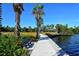 Scenic waterfront walkway with lush landscaping and a peaceful bench at 600 Sutton Pl # B305, Longboat Key, FL 34228