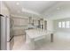 Modern kitchen with gray cabinetry, large island, stainless steel appliances, and stylish backsplash. Perfect for cooking at 6028 Cat Claw Ln, Bradenton, FL 34210