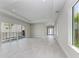 Open living room with tray ceilings, tile floors, large glass doors to outdoor spaces, and natural light at 6028 Cat Claw Ln, Bradenton, FL 34210