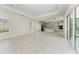 Bright open living space with kitchen island, gray cabinetry, light tile floors, and glass sliding doors for ample light at 6028 Cat Claw Ln, Bradenton, FL 34210