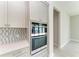 Built-in stainless steel oven with gray cabinets and drawers, complemented by a decorative backsplash at 6028 Cat Claw Ln, Bradenton, FL 34210