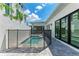 Backyard with a small, gated pool, concrete paver decking, and sliding glass doors at 6028 Cat Claw Ln, Bradenton, FL 34210