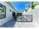 Backyard with a small, gated pool, concrete paver decking, and sliding glass doors at 6028 Cat Claw Ln, Bradenton, FL 34210