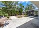 The backyard features a concrete patio surrounded by lush tropical landscaping and a screened-in lanai at 609 Glen Oak Rd, Venice, FL 34293