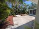 Backyard featuring mature landscaping and a concrete patio at 609 Glen Oak Rd, Venice, FL 34293
