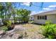 View of the side yard showing home exterior, privacy fence, and tropical landscaping at 609 Glen Oak Rd, Venice, FL 34293