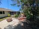Backyard featuring a fire pit area, landscaping, and screened-in patio at 609 Glen Oak Rd, Venice, FL 34293
