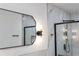 Modern bathroom features a sleek black-framed mirror, stylish lighting and elegant marble-look tile at 609 Glen Oak Rd, Venice, FL 34293