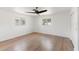 Bright bedroom featuring hardwood floors, a ceiling fan, and natural light from two windows at 609 Glen Oak Rd, Venice, FL 34293