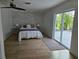 Bedroom features wood flooring, ceiling fan and sliding doors leading to the backyard at 609 Glen Oak Rd, Venice, FL 34293